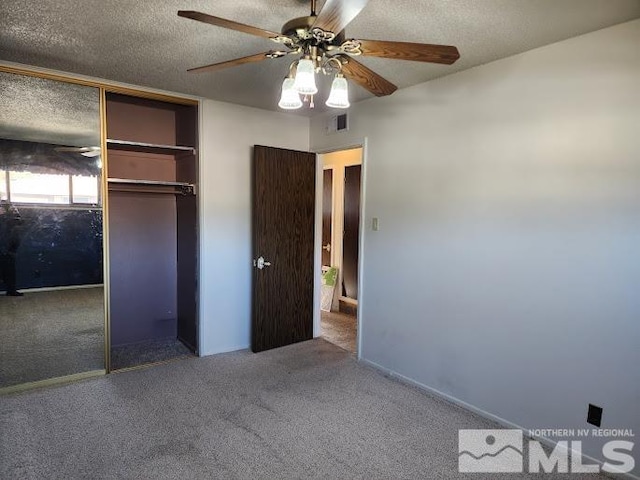 unfurnished bedroom with carpet flooring, a textured ceiling, ceiling fan, and a closet