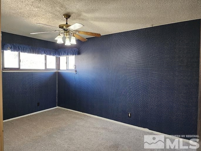 carpeted empty room with a textured ceiling, a wealth of natural light, and ceiling fan