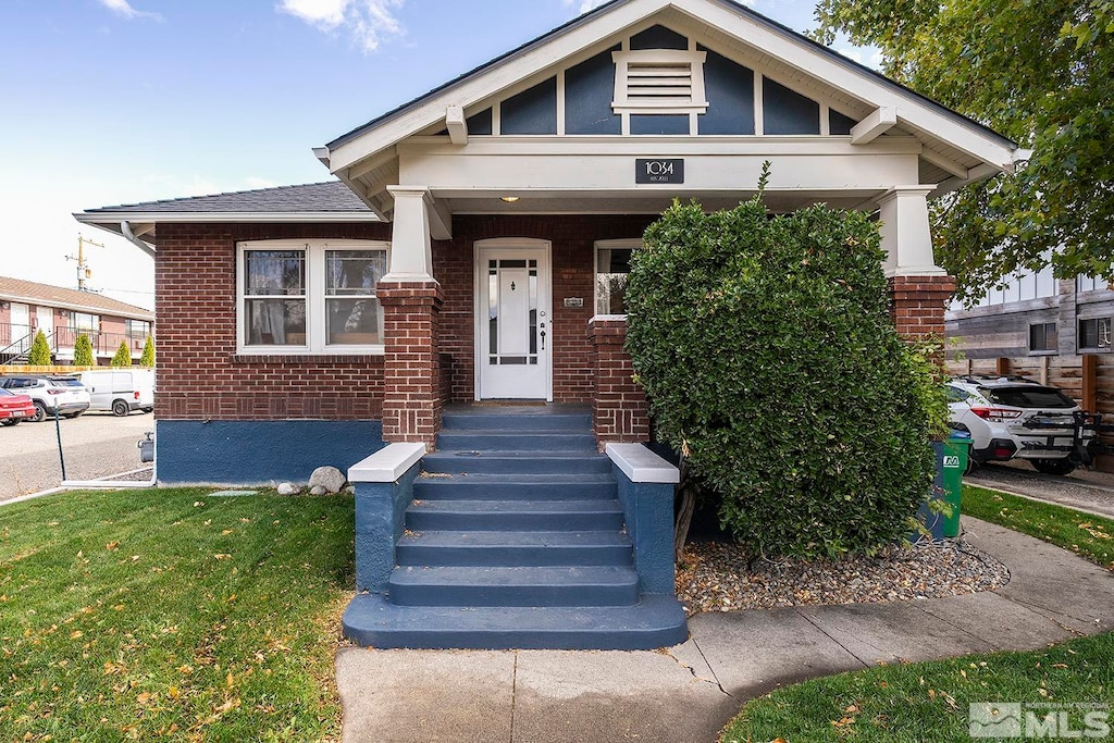 view of front of house with a front yard and a porch