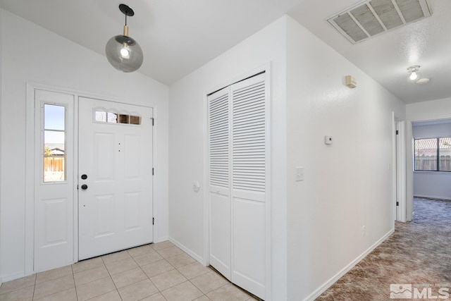 tiled entrance foyer featuring vaulted ceiling