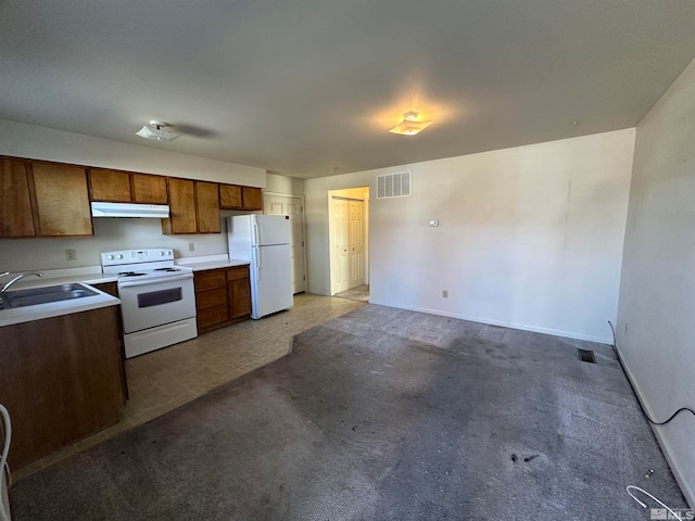 kitchen with light colored carpet, sink, and white appliances