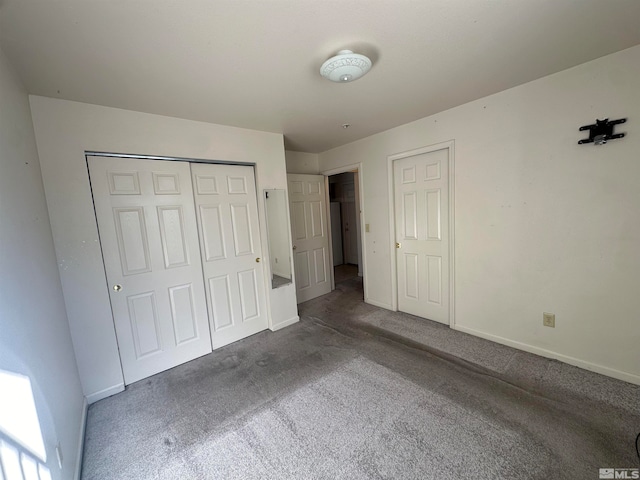 unfurnished bedroom featuring a closet and dark colored carpet