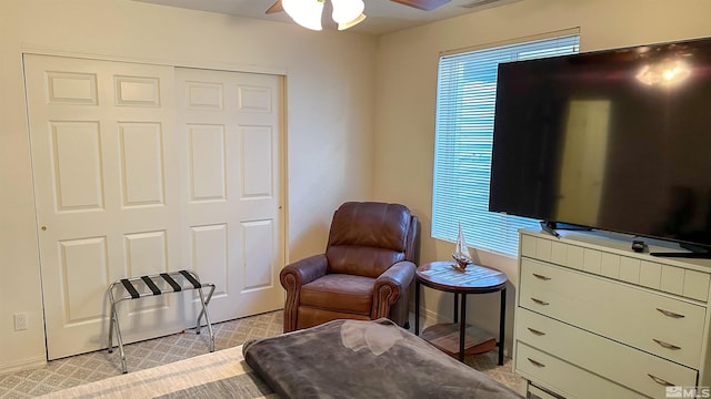 living area featuring ceiling fan and light carpet