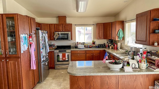 kitchen with lofted ceiling, sink, kitchen peninsula, and stainless steel appliances