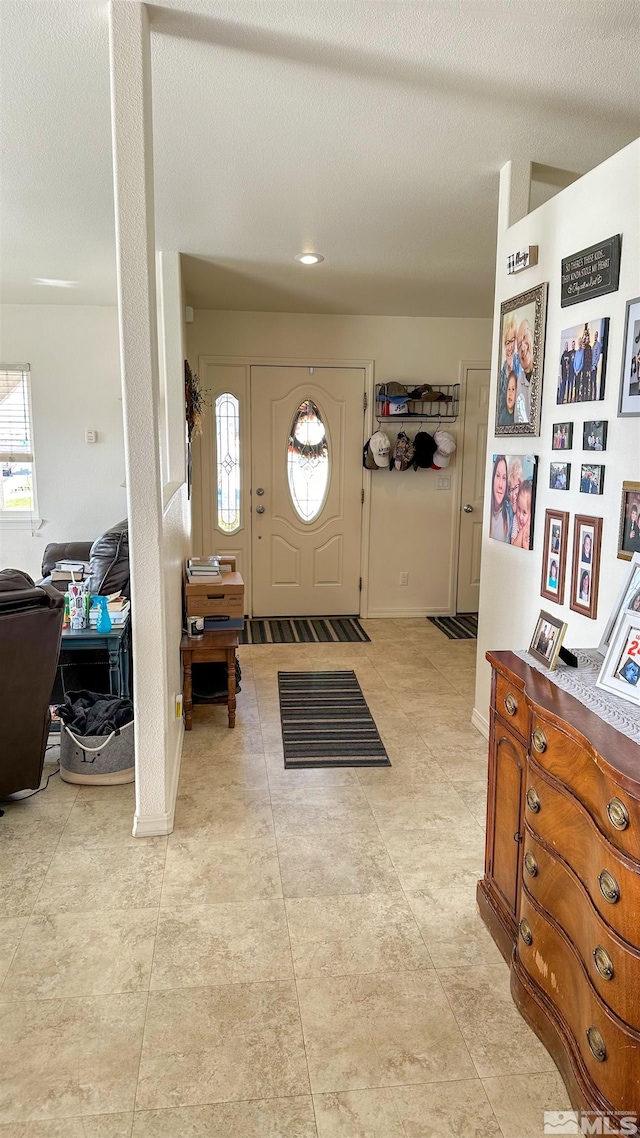 entrance foyer with a textured ceiling and light tile patterned flooring