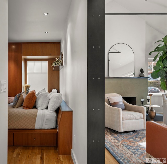 bedroom featuring light wood-type flooring and vaulted ceiling