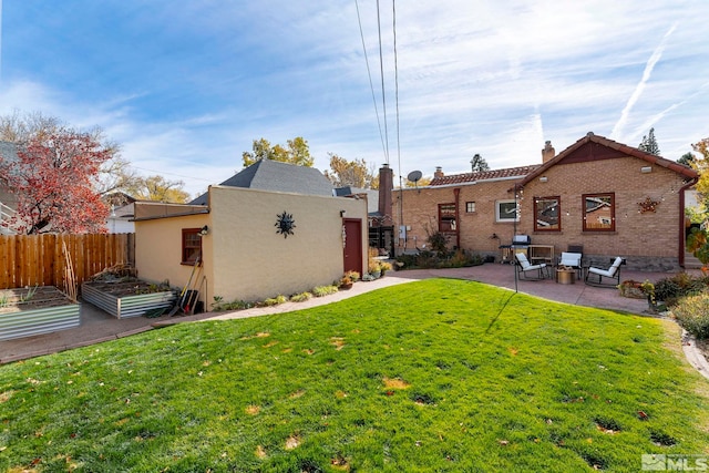 back of property featuring a lawn and a patio area