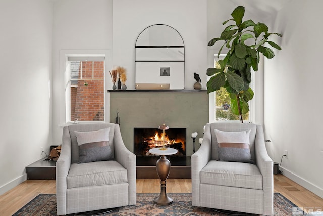 sitting room with a wealth of natural light and hardwood / wood-style flooring