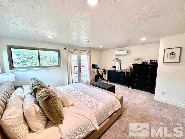 carpeted bedroom with multiple windows, a textured ceiling, and a wall mounted AC