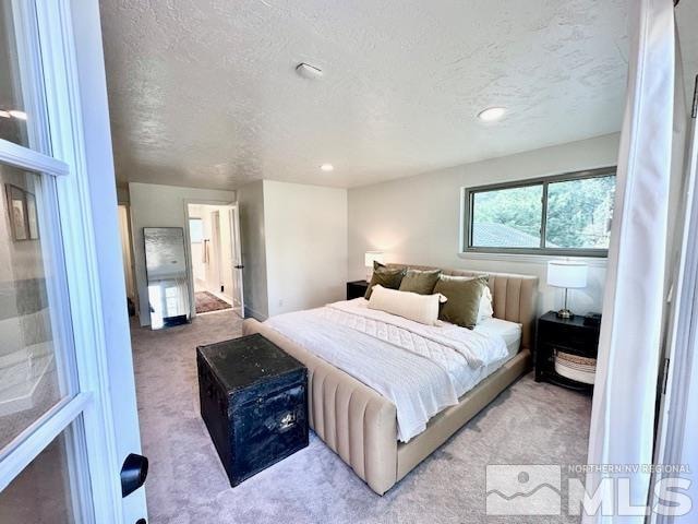 carpeted bedroom featuring a textured ceiling