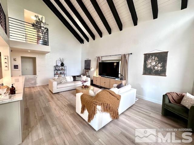 living room featuring wooden ceiling, beamed ceiling, light wood-type flooring, and high vaulted ceiling