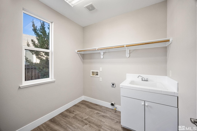 washroom featuring wood-type flooring, cabinets, electric dryer hookup, sink, and hookup for a washing machine