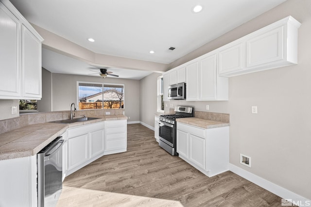 kitchen with white cabinetry, stainless steel appliances, and sink