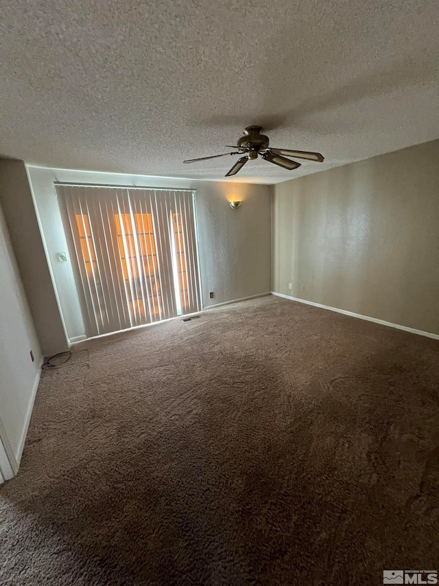 carpeted empty room with ceiling fan and a textured ceiling