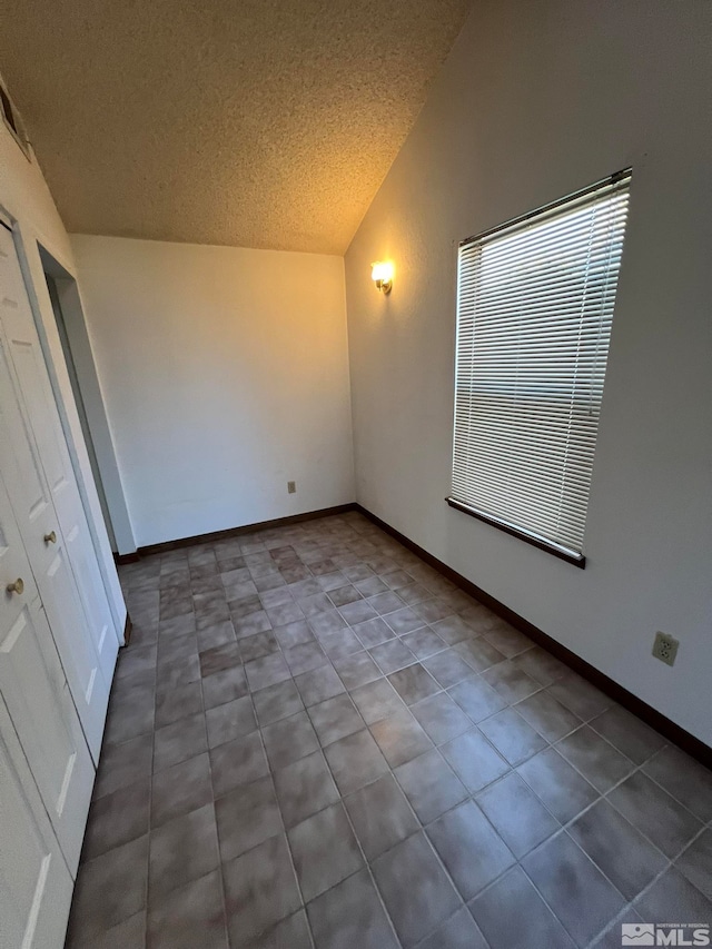 interior space featuring a textured ceiling and lofted ceiling