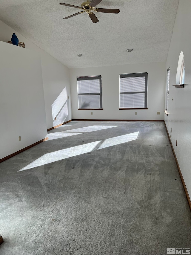 empty room featuring ceiling fan, carpet floors, and a textured ceiling