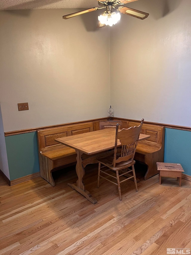 dining area with ceiling fan, light hardwood / wood-style floors, and a textured ceiling