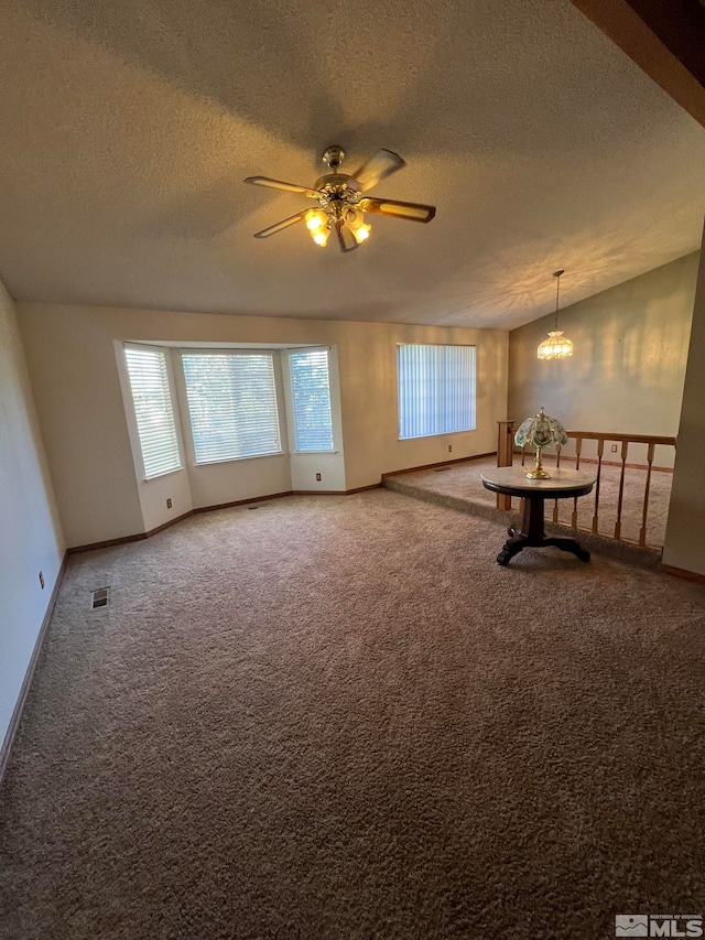 unfurnished room featuring carpet flooring, a textured ceiling, and ceiling fan with notable chandelier