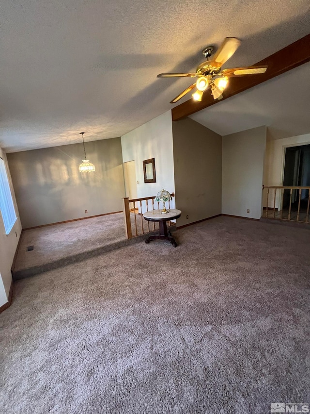 unfurnished room featuring a textured ceiling, ceiling fan with notable chandelier, carpet floors, and vaulted ceiling