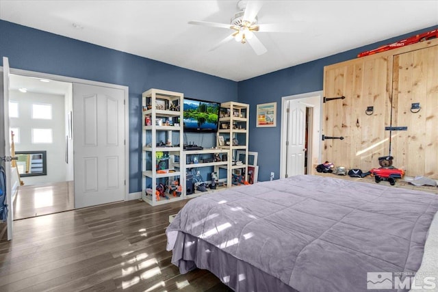 bedroom with dark wood-type flooring, ceiling fan, and a closet