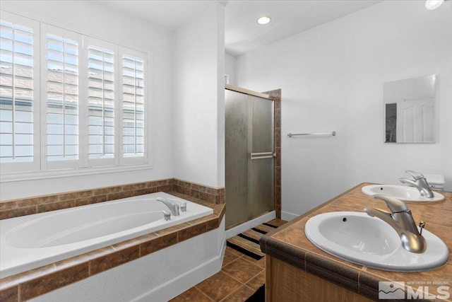 bathroom with tile patterned flooring, shower with separate bathtub, and sink