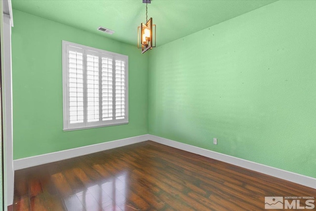 unfurnished room with dark hardwood / wood-style floors and a chandelier