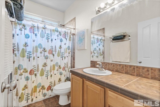 bathroom featuring vanity, curtained shower, tile patterned flooring, and toilet