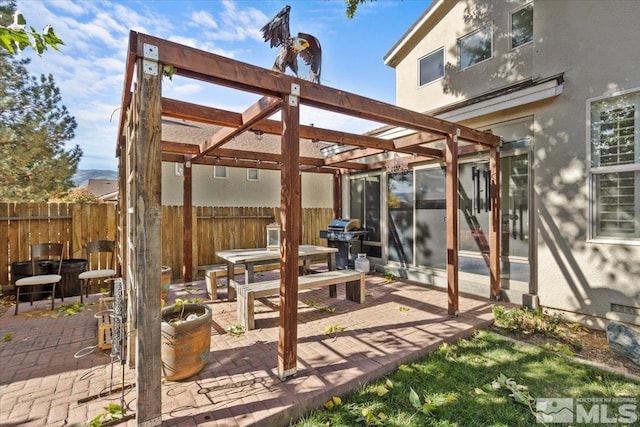 view of patio with area for grilling and a pergola