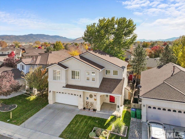 view of front of house with a mountain view, a garage, and a front yard