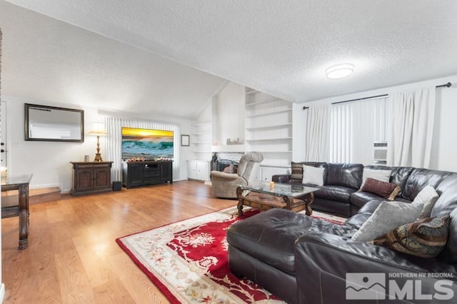 living room featuring wood-type flooring, a textured ceiling, built in features, and lofted ceiling