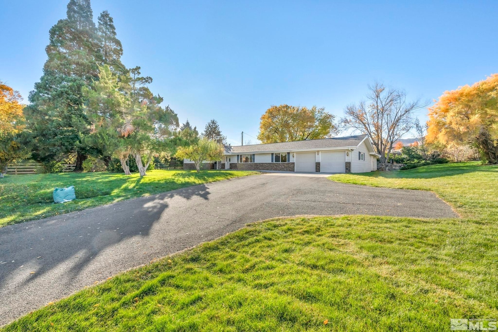 single story home with a garage and a front lawn