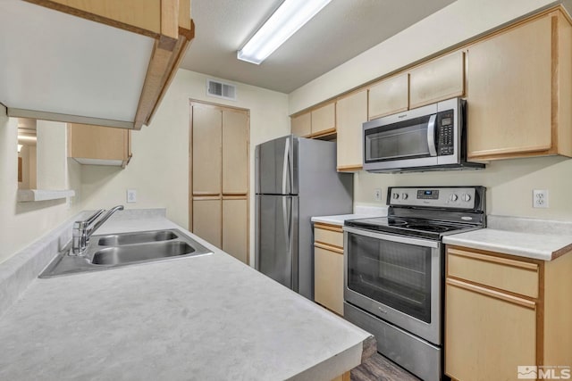 kitchen featuring hardwood / wood-style flooring, appliances with stainless steel finishes, sink, and light brown cabinetry