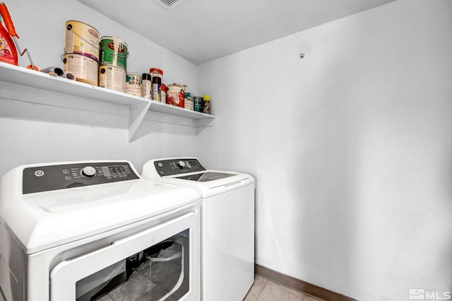 laundry room featuring washer and clothes dryer and light tile patterned floors