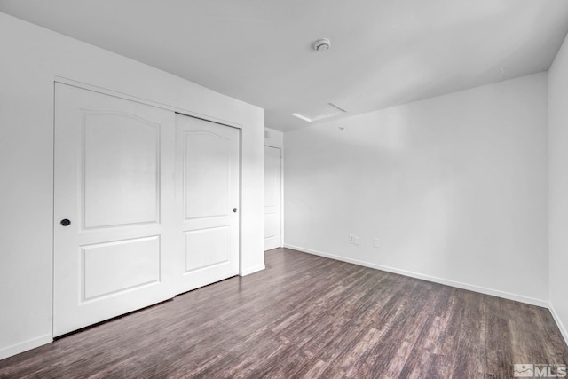 unfurnished bedroom featuring dark wood-type flooring and a closet