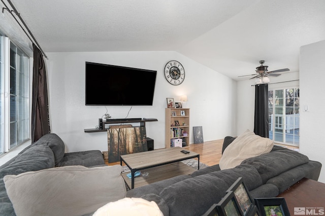 living room with hardwood / wood-style flooring, ceiling fan, a textured ceiling, and lofted ceiling