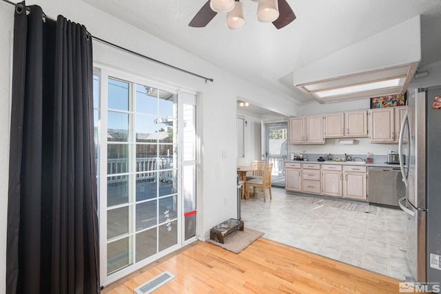 kitchen with plenty of natural light, light brown cabinetry, light wood-type flooring, and stainless steel appliances