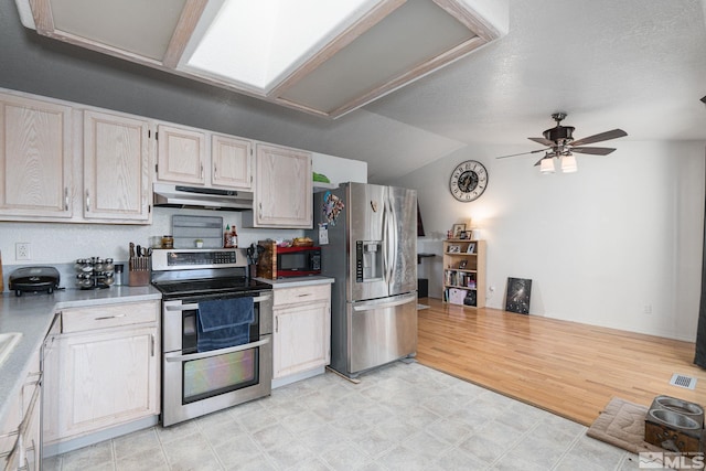 kitchen featuring stainless steel appliances, light hardwood / wood-style floors, ceiling fan, a textured ceiling, and lofted ceiling