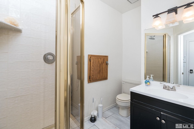 bathroom featuring vanity, toilet, and a shower with door