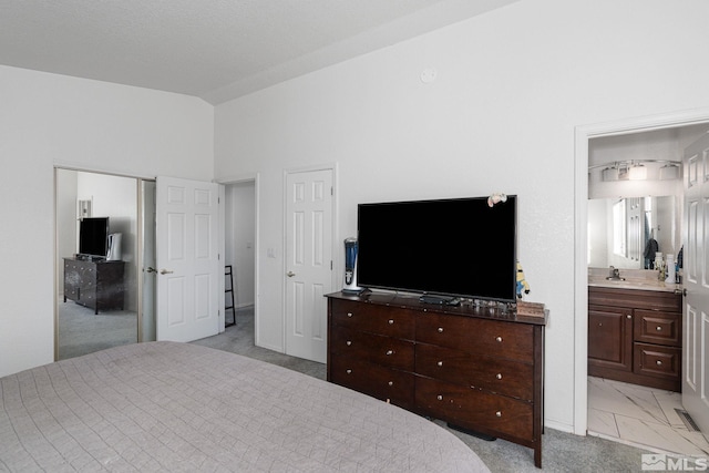 bedroom featuring light colored carpet and ensuite bath