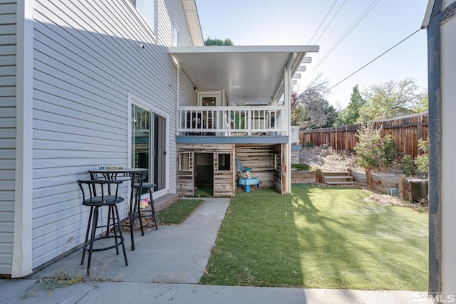 rear view of property featuring a patio area and a lawn