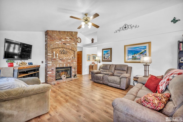 living room featuring lofted ceiling, hardwood / wood-style flooring, ceiling fan, and a fireplace