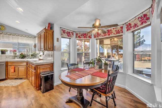 dining space featuring light hardwood / wood-style flooring, lofted ceiling, ceiling fan, and plenty of natural light