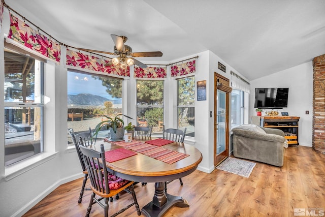 dining space with hardwood / wood-style floors, ceiling fan, and vaulted ceiling