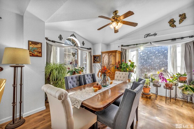 dining space featuring ceiling fan, wood-type flooring, and lofted ceiling