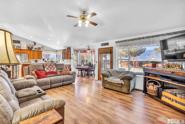 living room featuring ceiling fan, light hardwood / wood-style flooring, and lofted ceiling