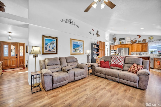 living room with light hardwood / wood-style floors, ceiling fan, and high vaulted ceiling