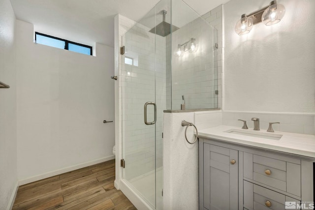 bathroom with an enclosed shower, vanity, hardwood / wood-style flooring, and toilet