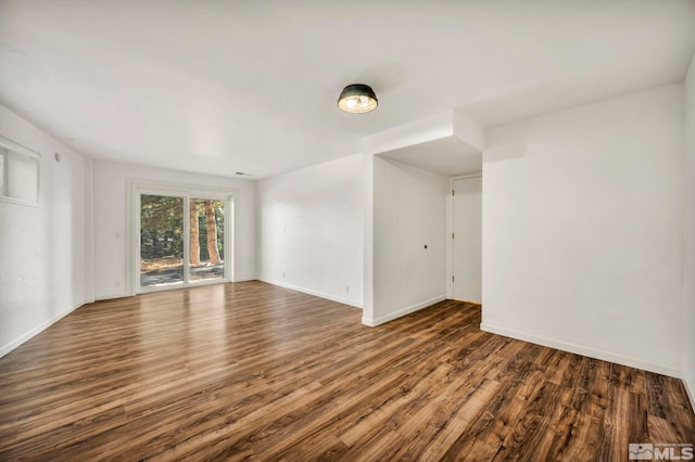 empty room with dark hardwood / wood-style flooring