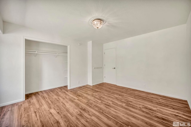 unfurnished bedroom with a closet and light wood-type flooring