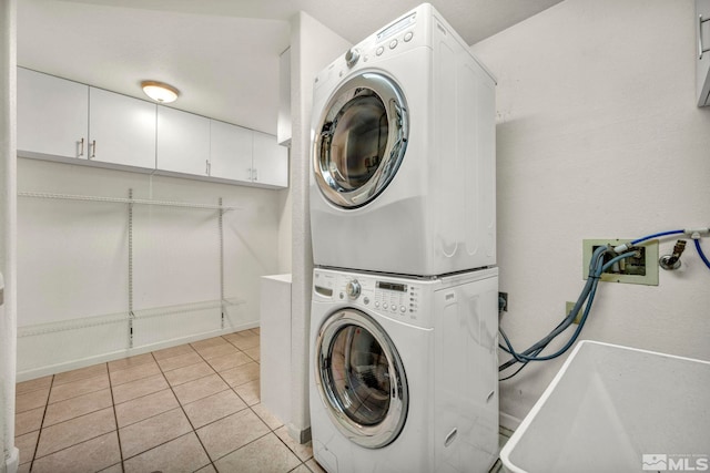 laundry room with stacked washing maching and dryer and light tile patterned flooring